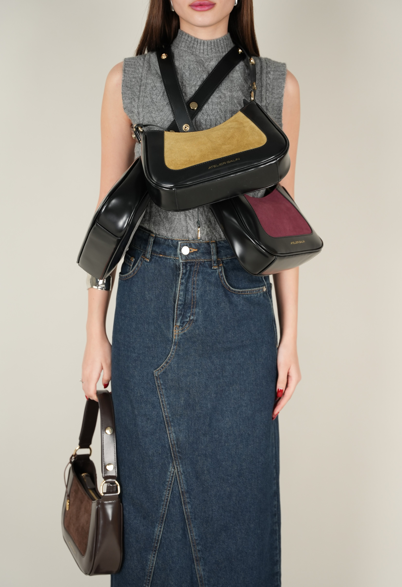 Person holding atelier galin jasmine bags of different colors against a neutral background