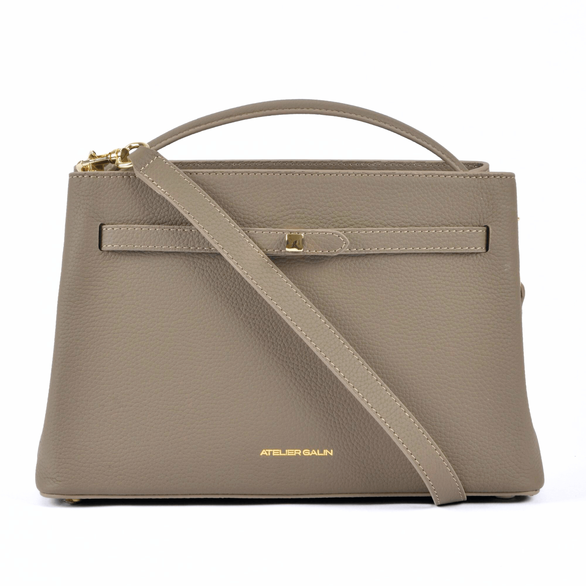 Beige atelier galin cube lock handbag with a shoulder strap on a white background