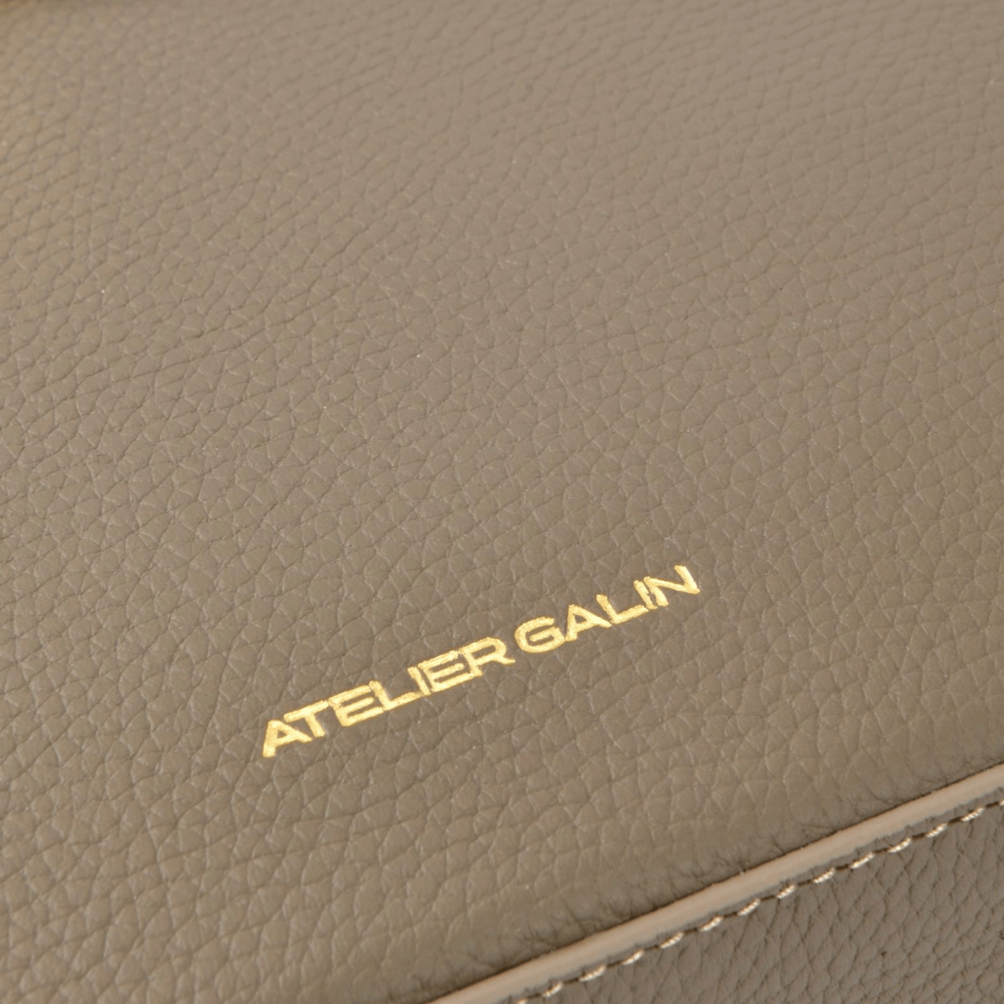 Close-up of a brown leather product with 'Atelier Galin' branding.