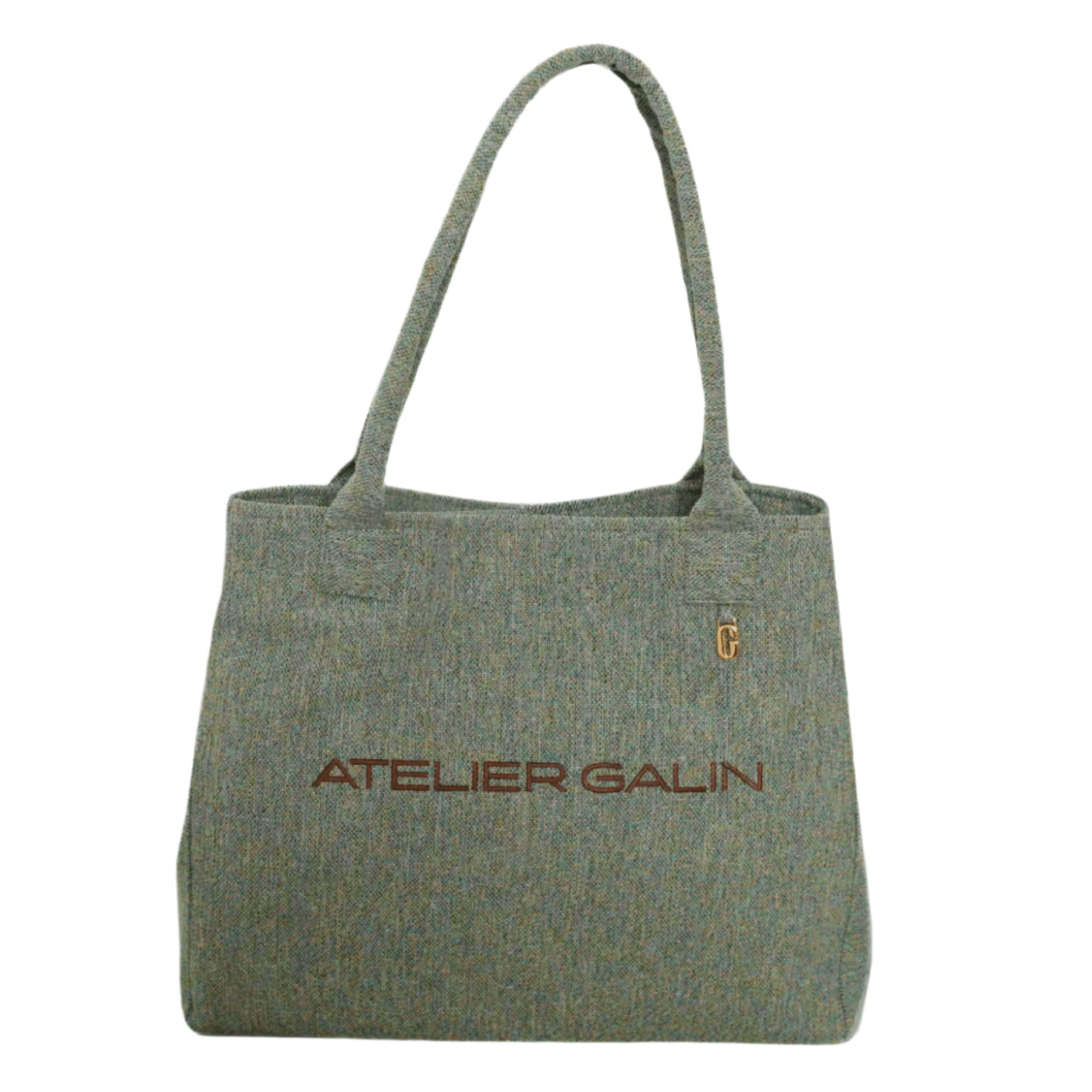 Green tote bag with 'Atelier Galin' branding on a white background